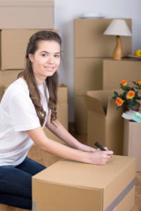 Apartments in Northwest San Antonio A woman sitting on the floor in front of moving boxes in an apartment for rent.