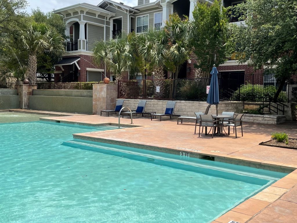 Apartments in NW San Antonio, TX - Community Pool and Patio with Tables & Lounge Chairs